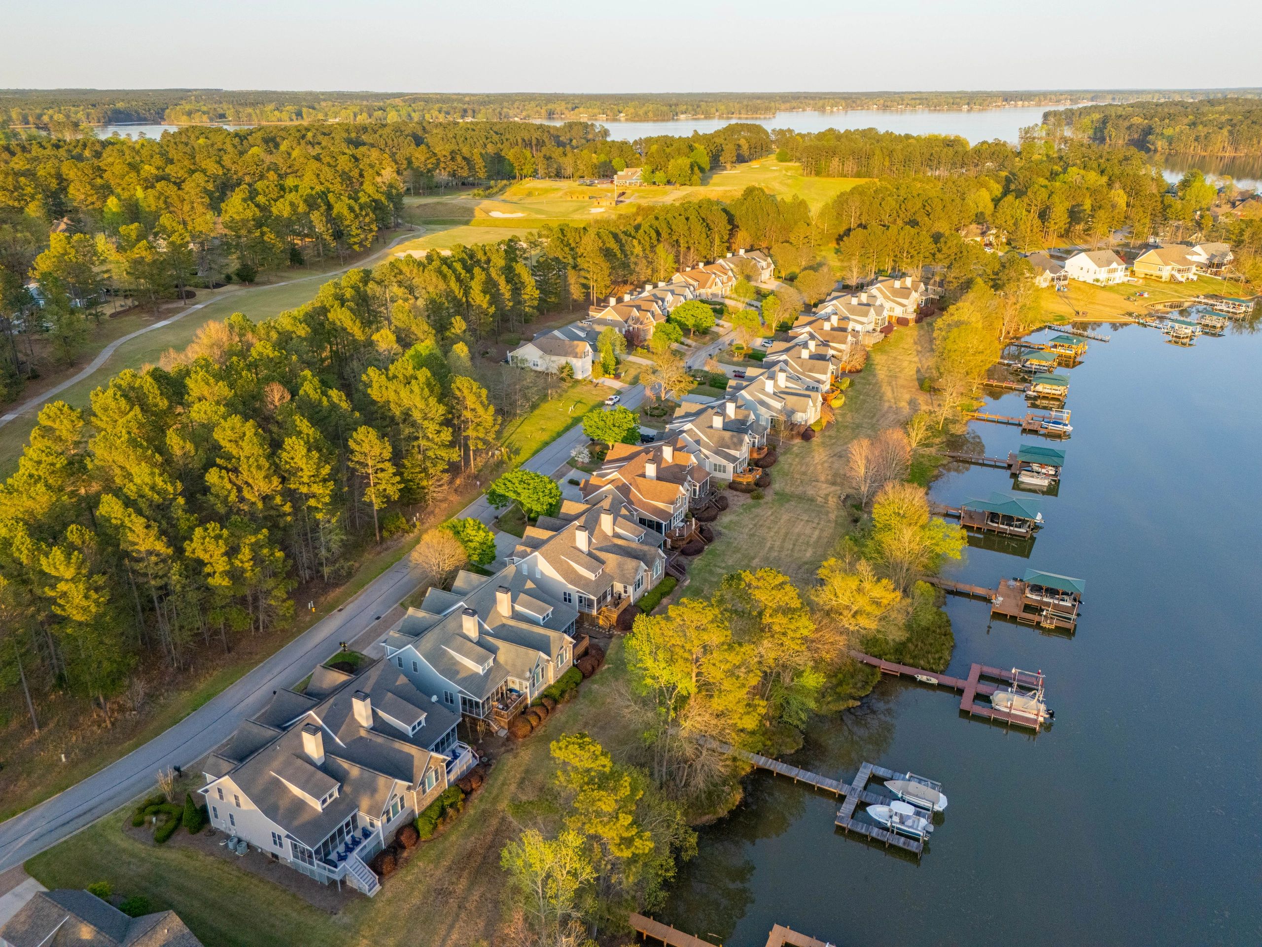 Aerial property photograph of lakeside homes, private docks, and surrounding landscape.